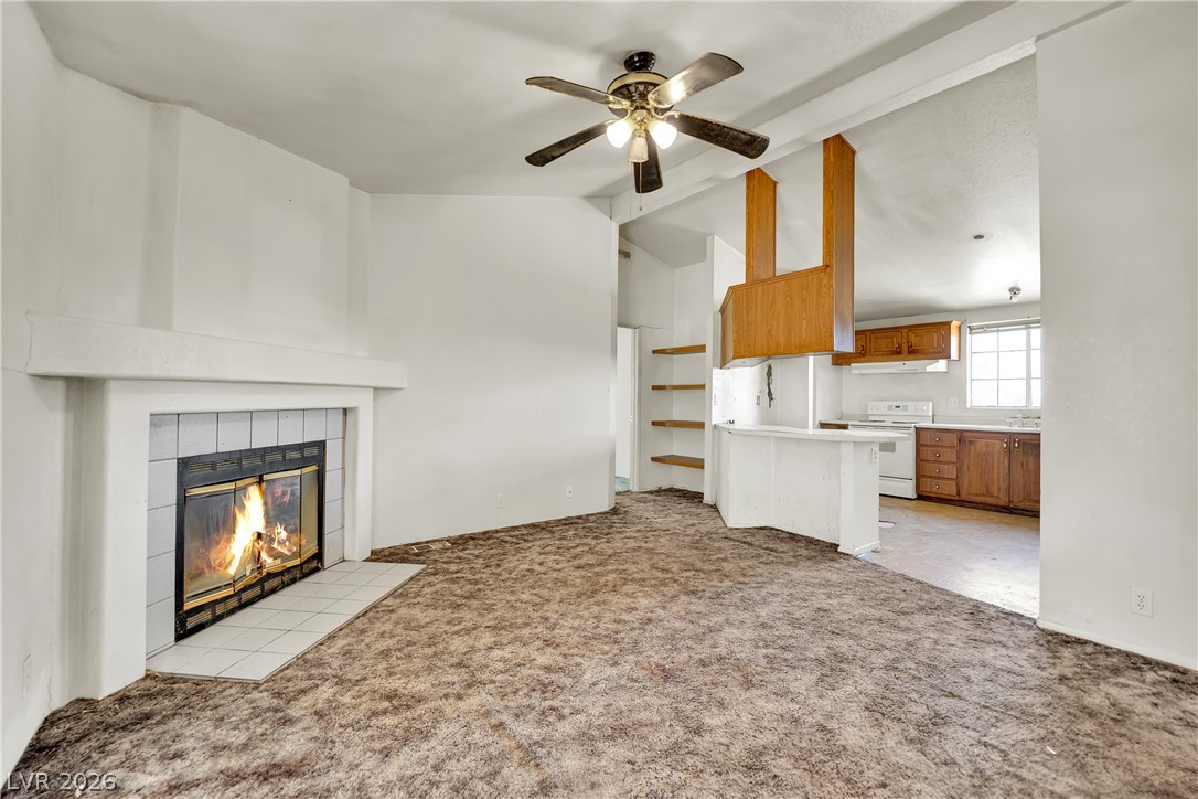 4361 Maple Road Pahrump, NV 89048 - Photo 17 of 46 A welcoming living area with a cozy fireplace and an open concept kitchen.