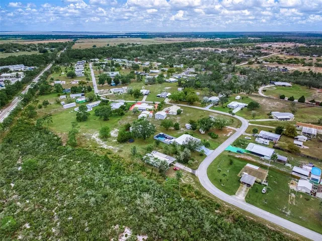 an aerial view of residential houses with outdoor space and trees