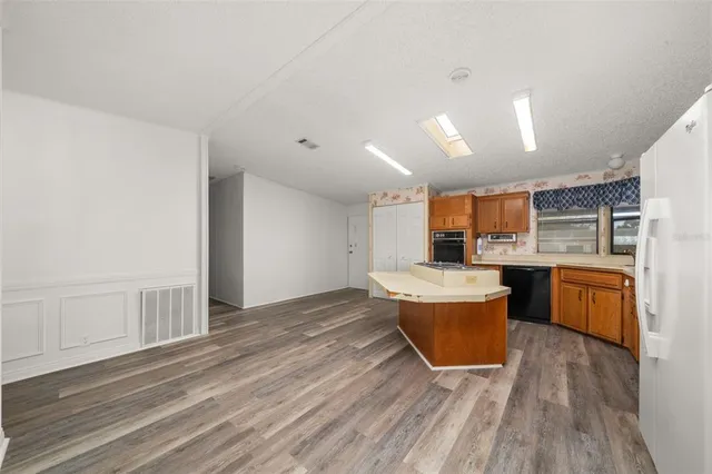 a kitchen with a sink cabinets and wooden floor