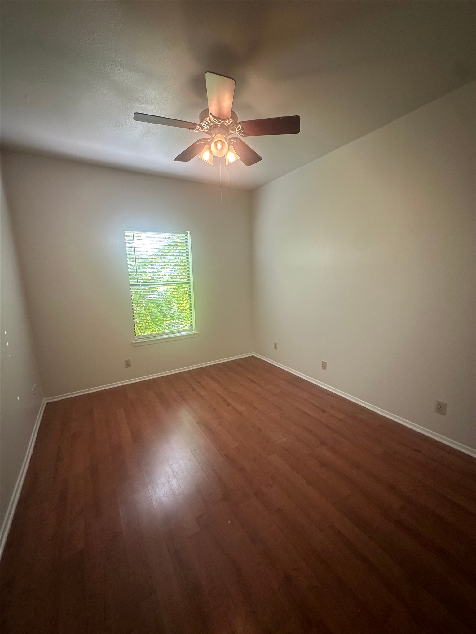 106 East 30th Street, Unit 101 Austin, TX 78705 - Photo 7 of 11 Empty room featuring dark wood-type flooring and a ceiling fan