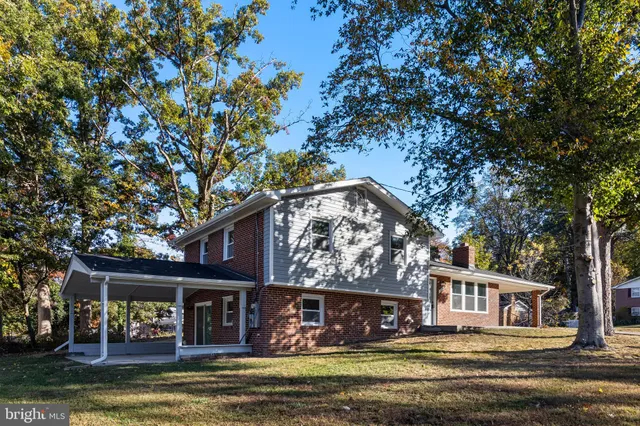 a front view of a house with a large tree