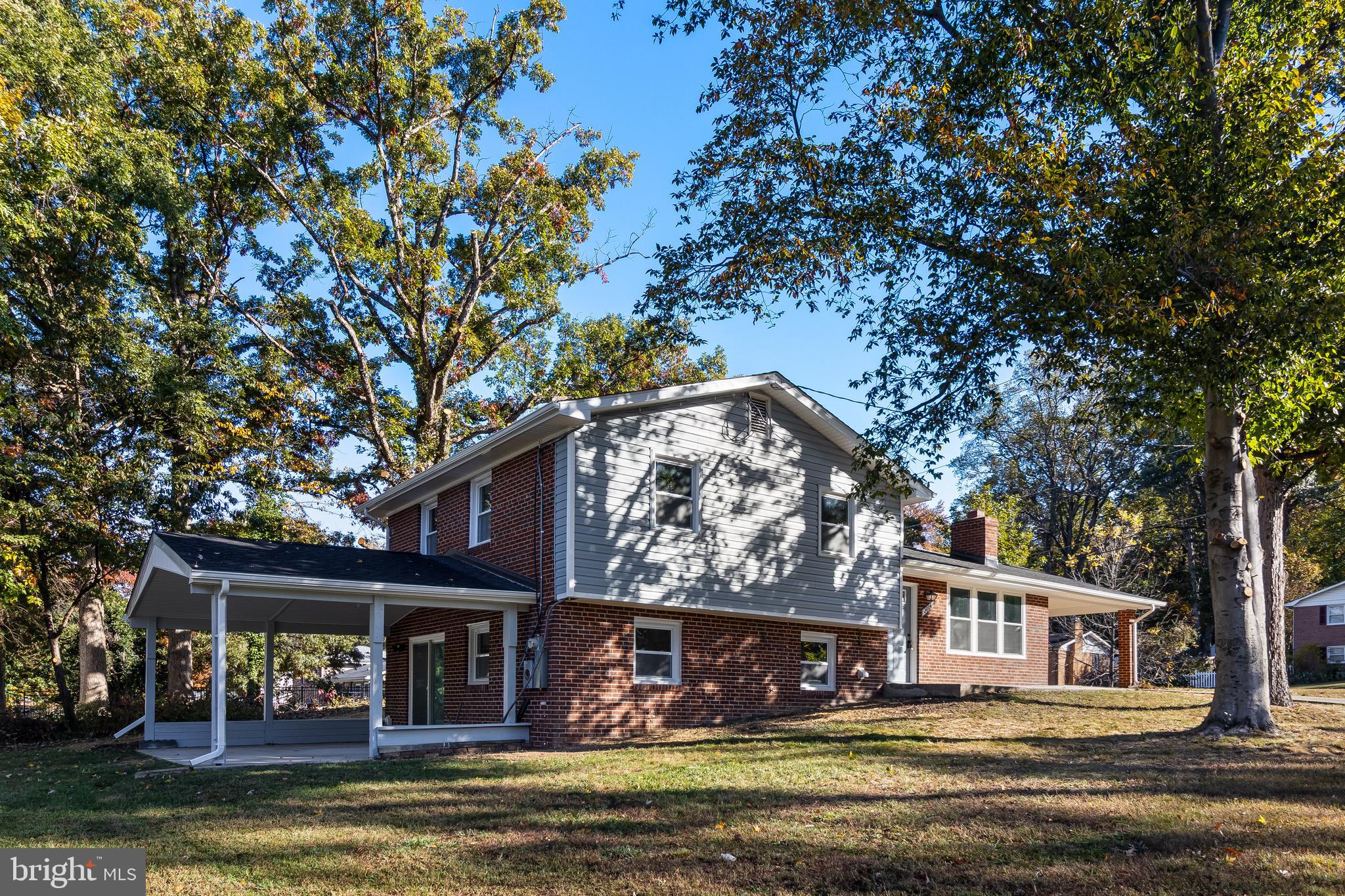a front view of a house with a large tree