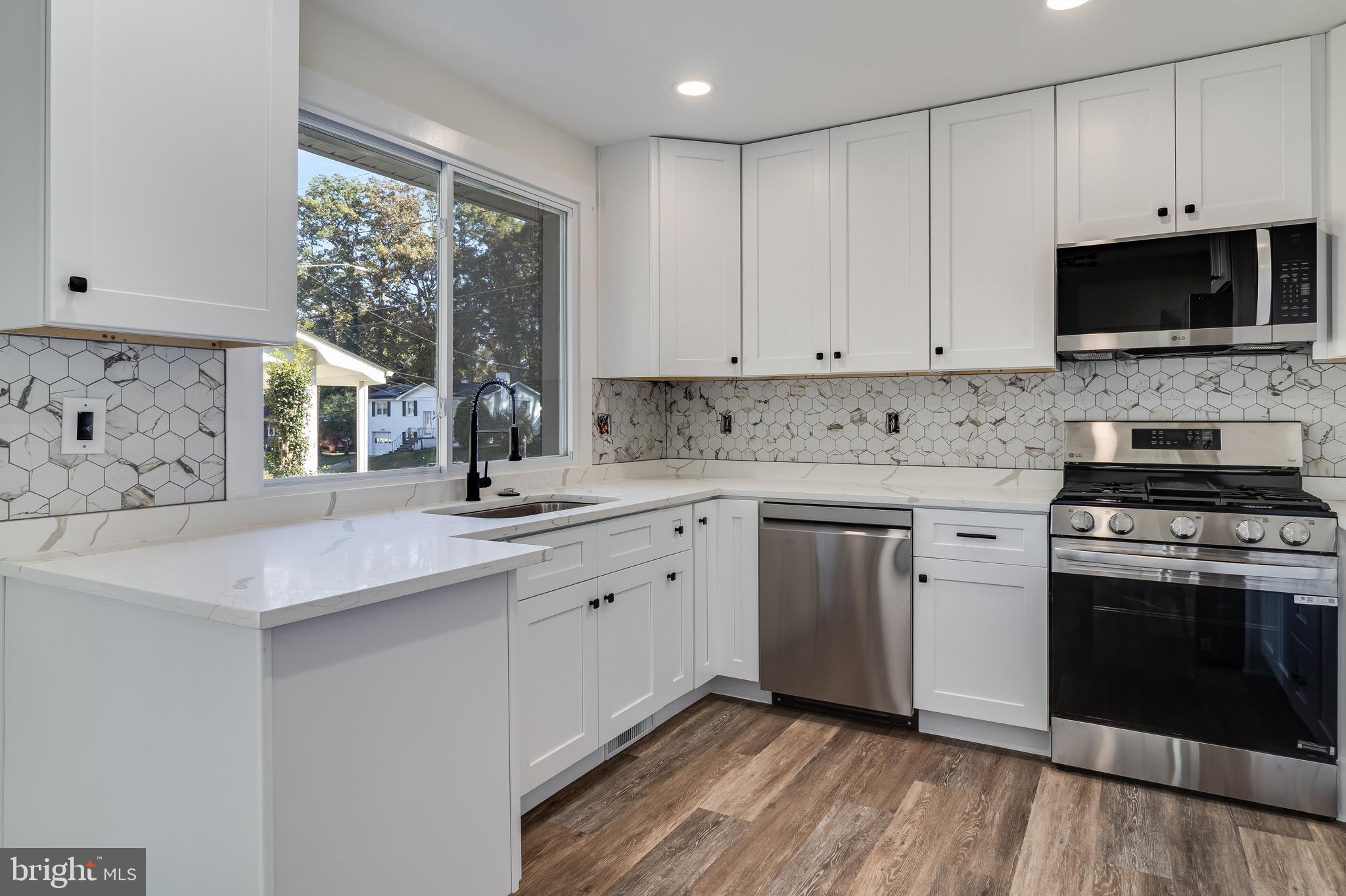 2804 Testway Avenue Fort Washington, MD 20744 - Photo 13 of 36 a kitchen with stainless steel appliances a stove sink microwave and cabinets