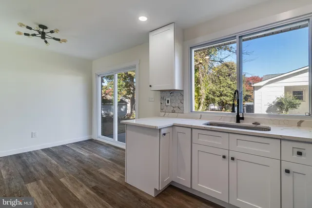 a kitchen with a refrigerator and white cabinets