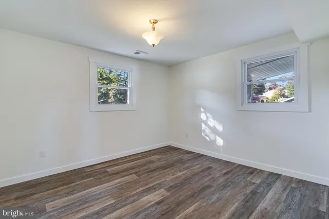 a view of room with hardwood floor and a ceiling fan