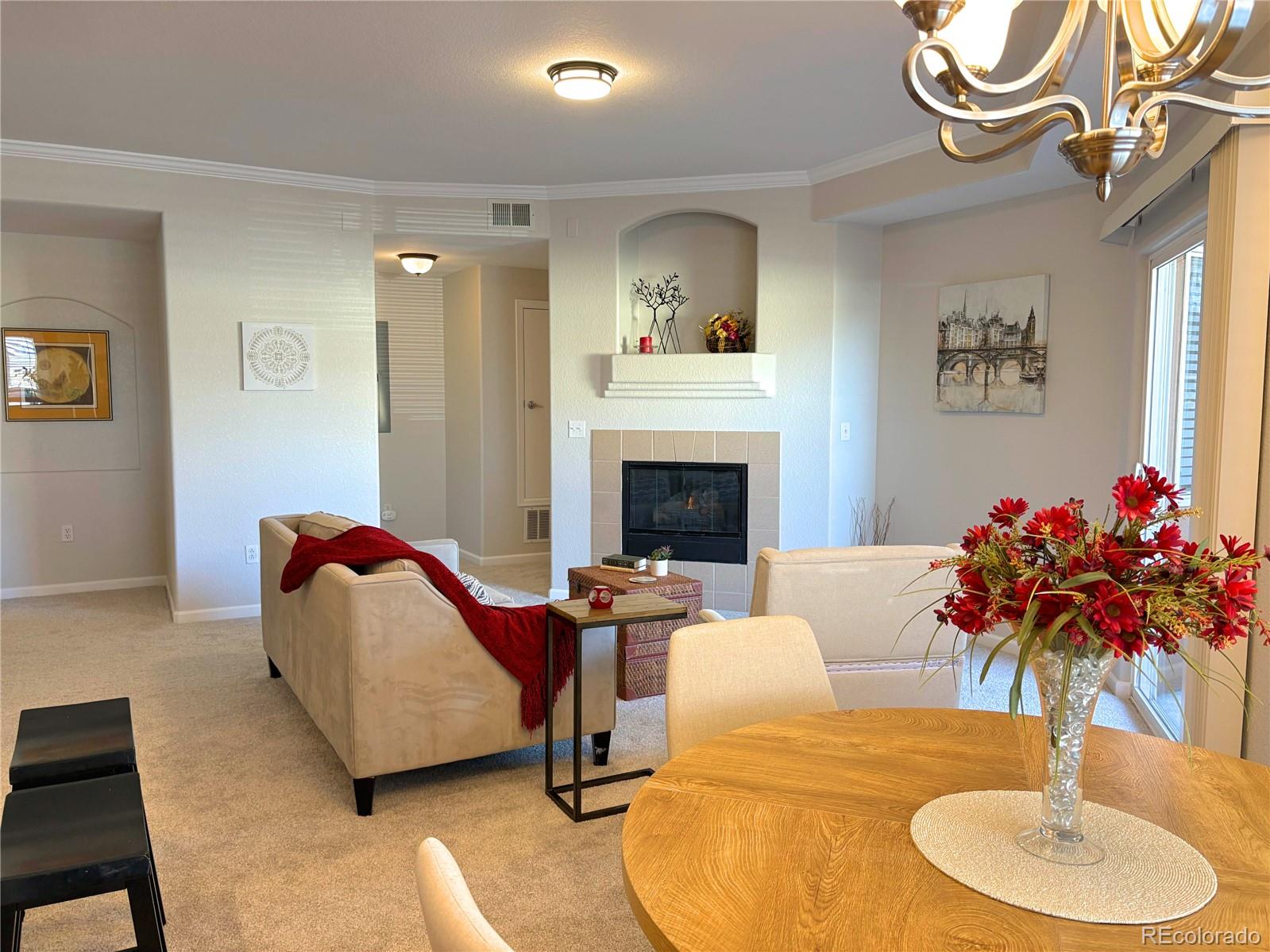 4608 Copeland Lane, Unit 101 Highlands Ranch, CO 80126 - Photo 3 of 16 a living room with furniture chandelier and a fireplace