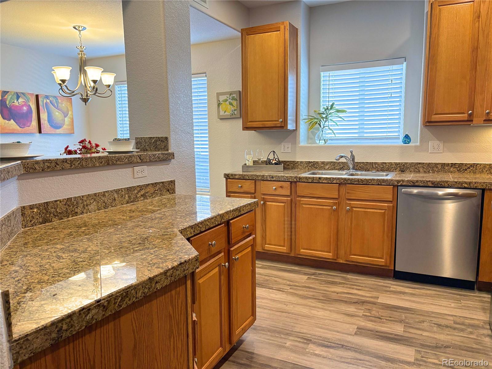 4608 Copeland Lane, Unit 101 Highlands Ranch, CO 80126 - Photo 7 of 16 a kitchen with stainless steel appliances granite countertop wooden floor sink stove and granite counter top