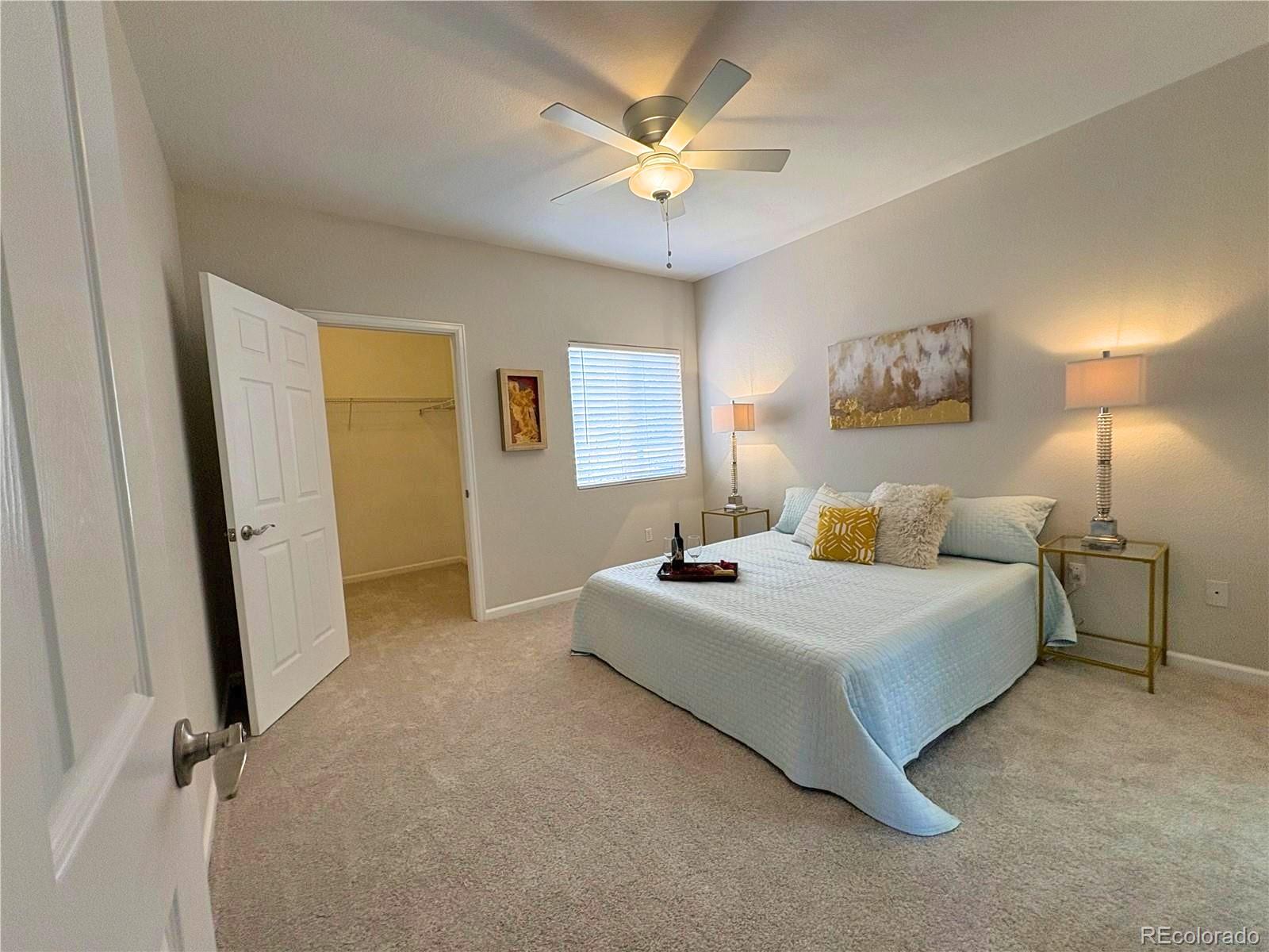 4608 Copeland Lane, Unit 101 Highlands Ranch, CO 80126 - Photo 9 of 16 a spacious bedroom with a bed and a chandelier