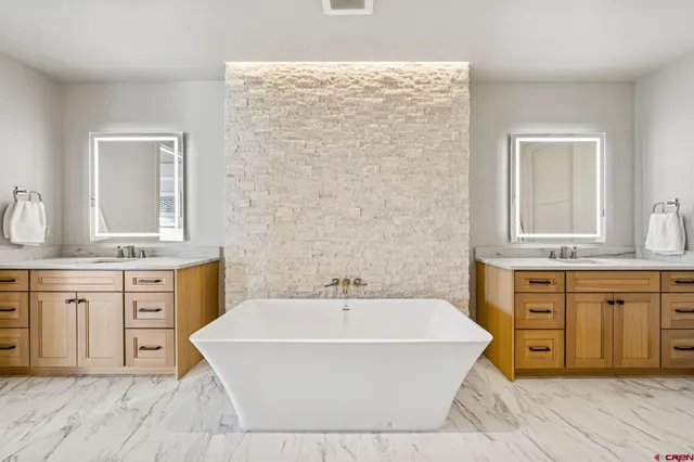 a spacious bathroom with a double vanity sink a mirror and a shower