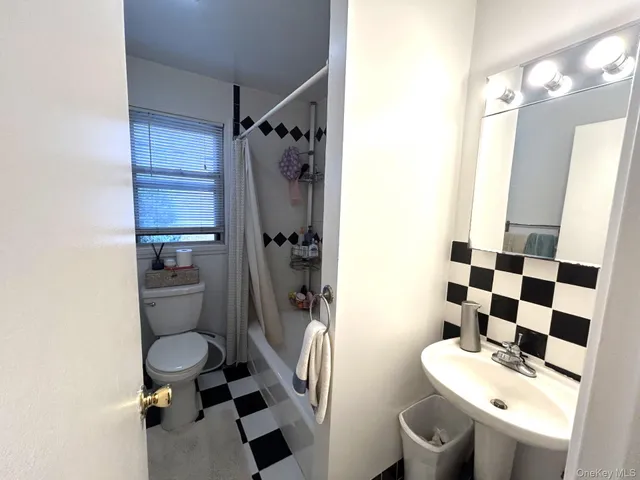 a bathroom with a sink a toilet a mirror and shower