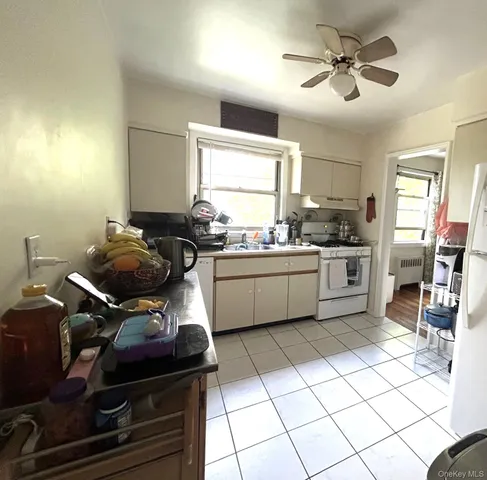 a kitchen with a sink a stove cabinets and a window