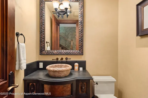 a bathroom with a granite countertop sink a mirror and toilet