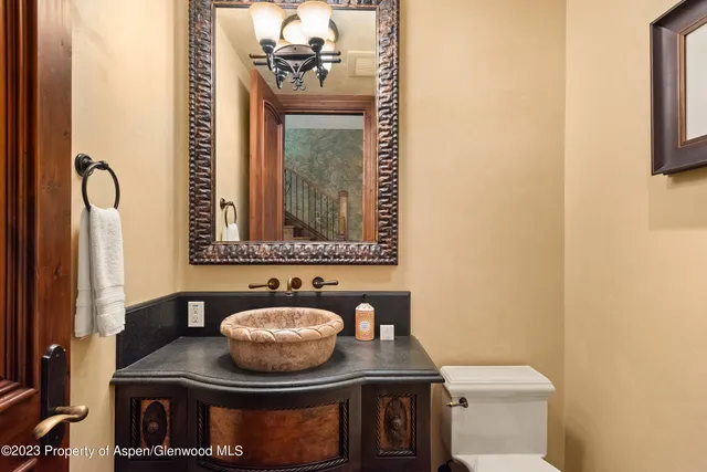 a bathroom with a granite countertop sink a mirror and toilet