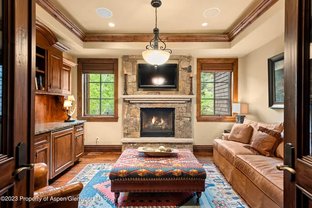 a living room with furniture a flat screen tv and a fireplace