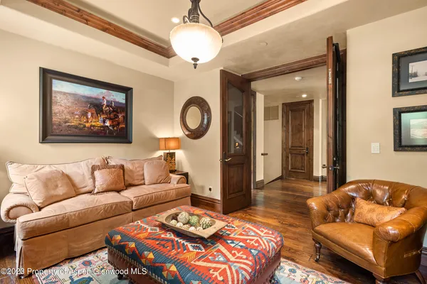 a living room with furniture a clock and a chandelier