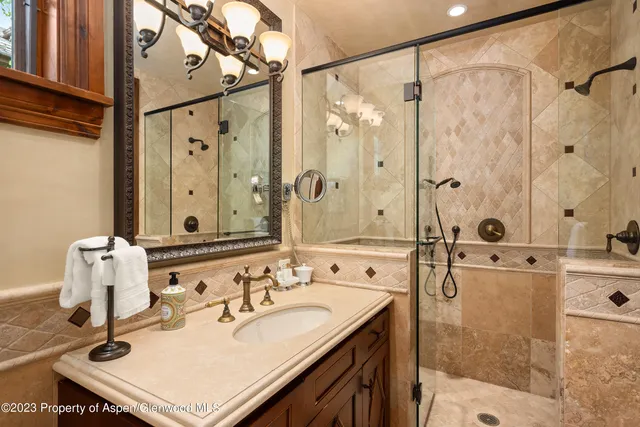 a bathroom with a sink mirror and shower