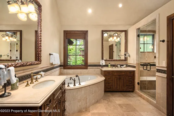 a bathroom with a tub sink and mirror