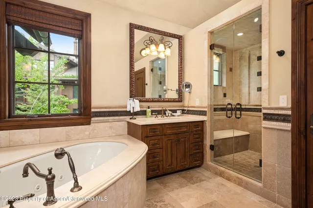 a bathroom with a tub sink and mirror