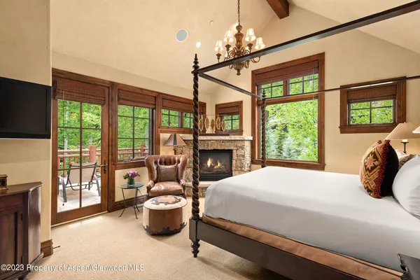 a bedroom with a bed and large windows