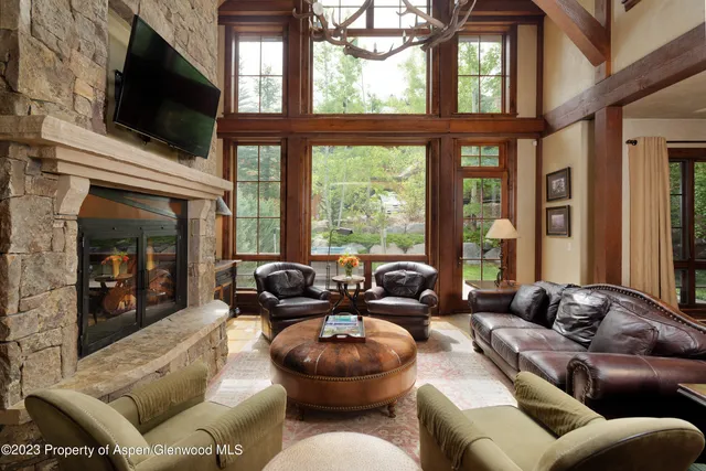 a living room with furniture a flat screen tv and a large window
