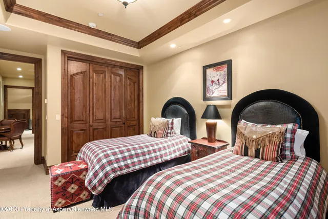 a bedroom with two beds and a chandelier