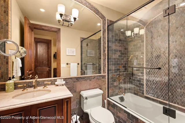 a bathroom with a granite countertop sink toilet a mirror and shower