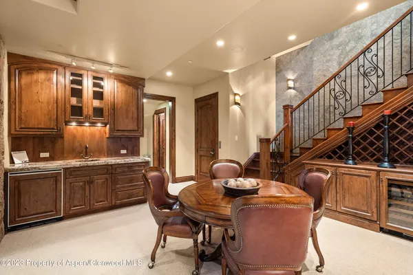 a dining room with furniture a kitchen and chandelier