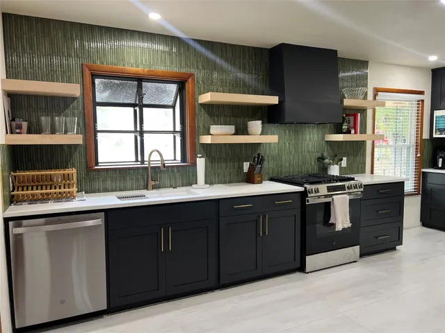 a kitchen with stainless steel appliances granite countertop a sink and a stove