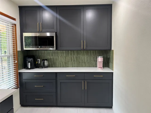 a kitchen with a sink a microwave and cabinets
