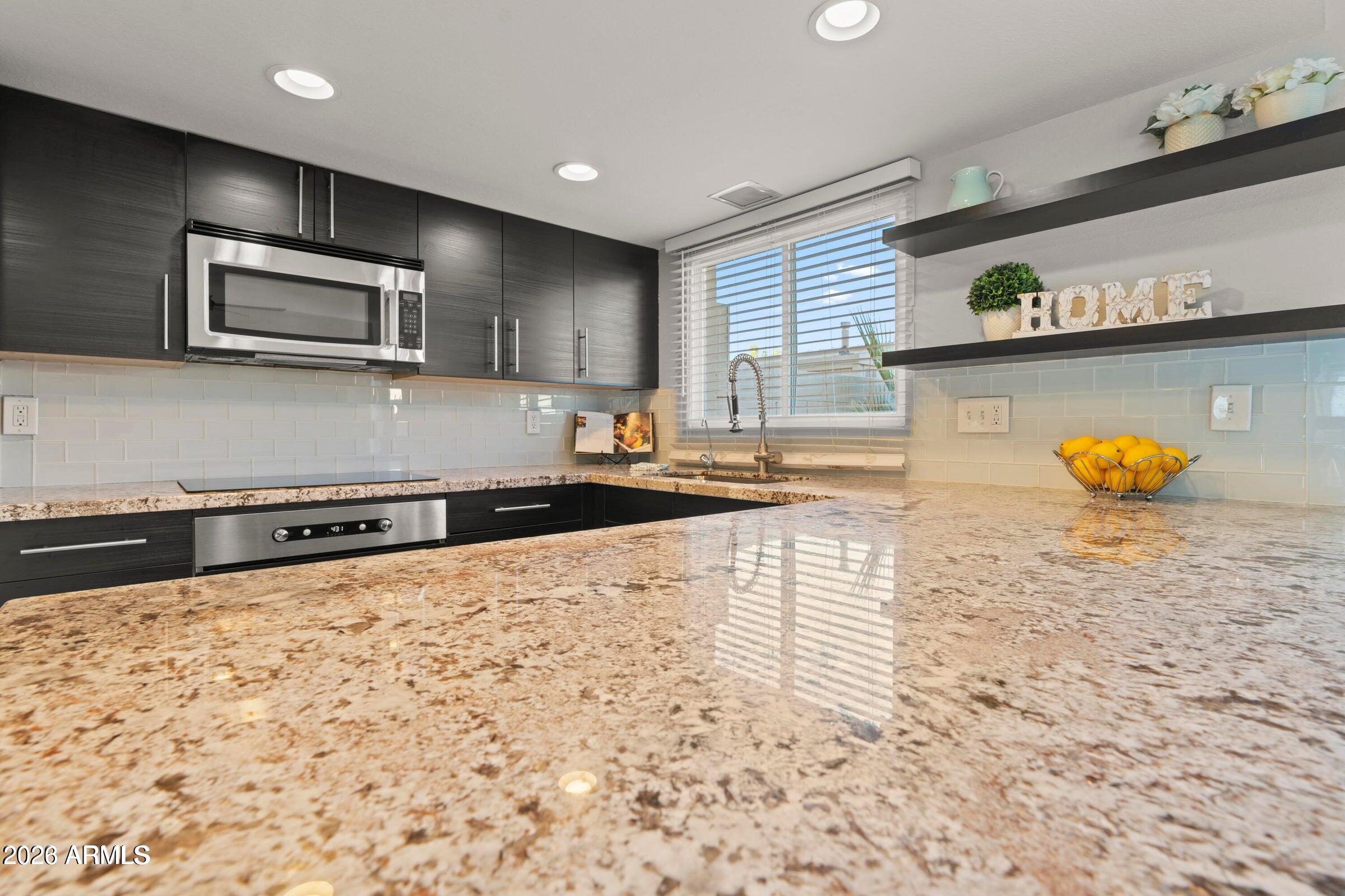 6909 East Osborn Road, Unit A Scottsdale, AZ 85251 - Photo 25 of 33 a kitchen with stainless steel appliances a sink and a microwave