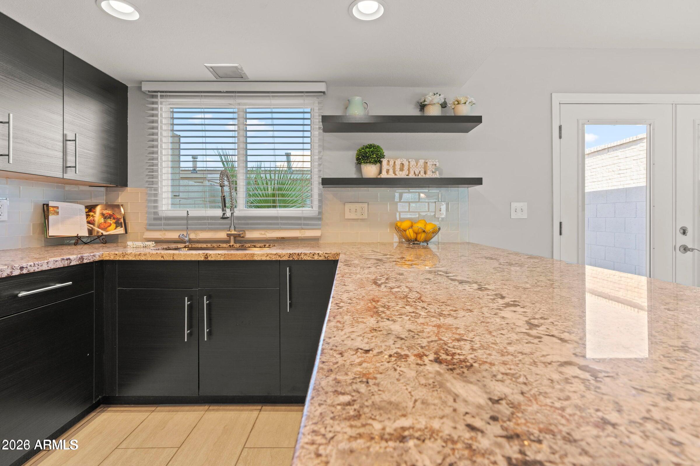 6909 East Osborn Road, Unit A Scottsdale, AZ 85251 - Photo 27 of 33 a kitchen with stainless steel appliances granite countertop a refrigerator and a sink