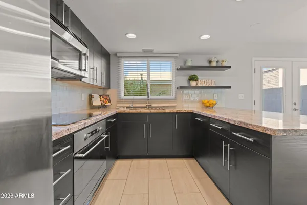 a kitchen with stainless steel appliances granite countertop a sink stove and cabinets