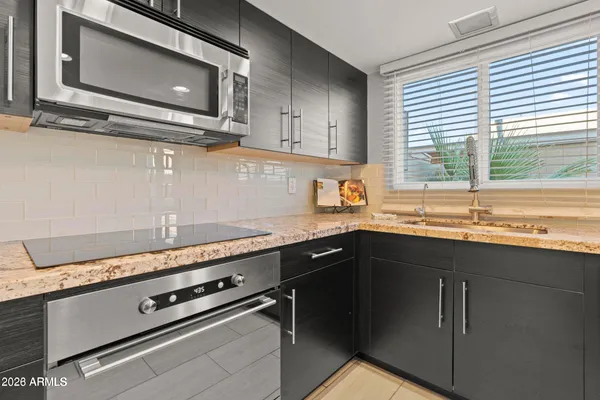 a kitchen with granite countertop a sink cabinets and window