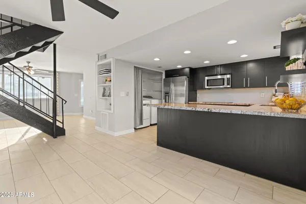 a view of kitchen with refrigerator cabinets and furniture
