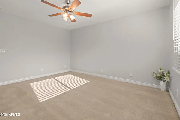 an empty room with windows and fan