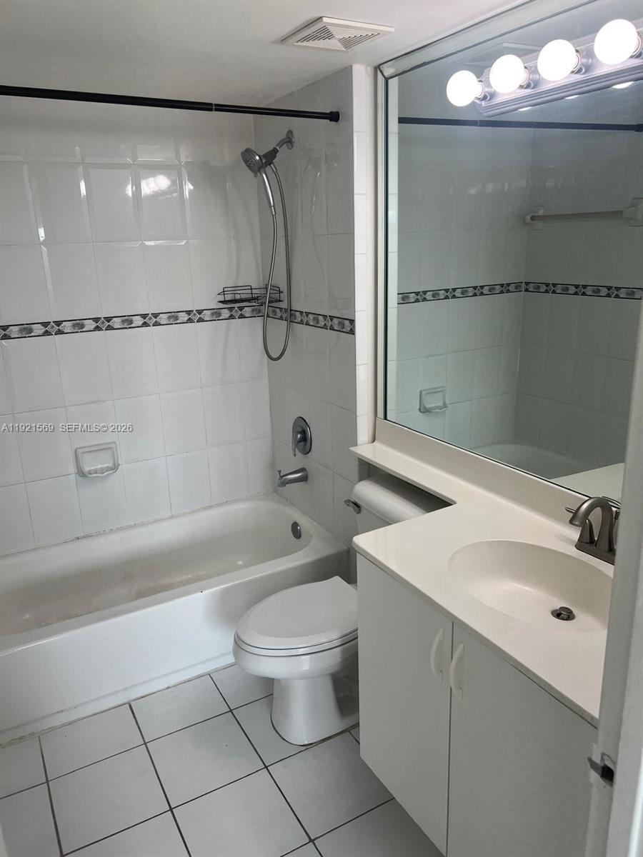 2475 Northwest 16th St Road, Unit 611 Miami, FL 33125 - Photo 10 of 11 a bathroom with a sink a toilet and shower