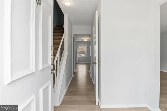 a view of a hallway with wooden floor and entryway