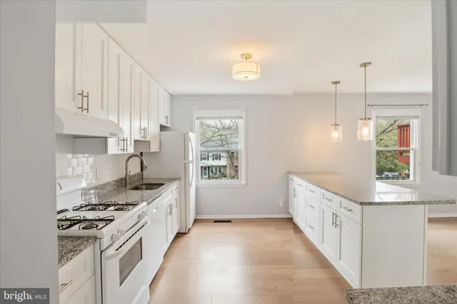 a kitchen with granite countertop a sink stove and cabinets
