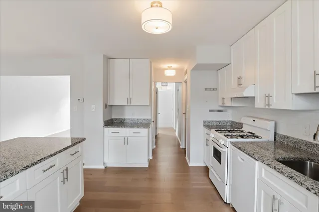 a kitchen with granite countertop cabinets stainless steel appliances and a counter space
