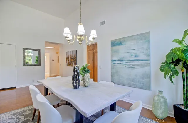 a kitchen with stainless steel appliances granite countertop a refrigerator a stove a sink a dining table and chairs