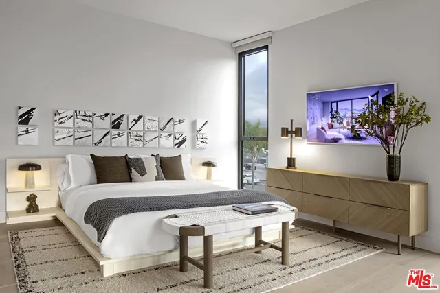 a bedroom with a bed and a potted plant on dresser