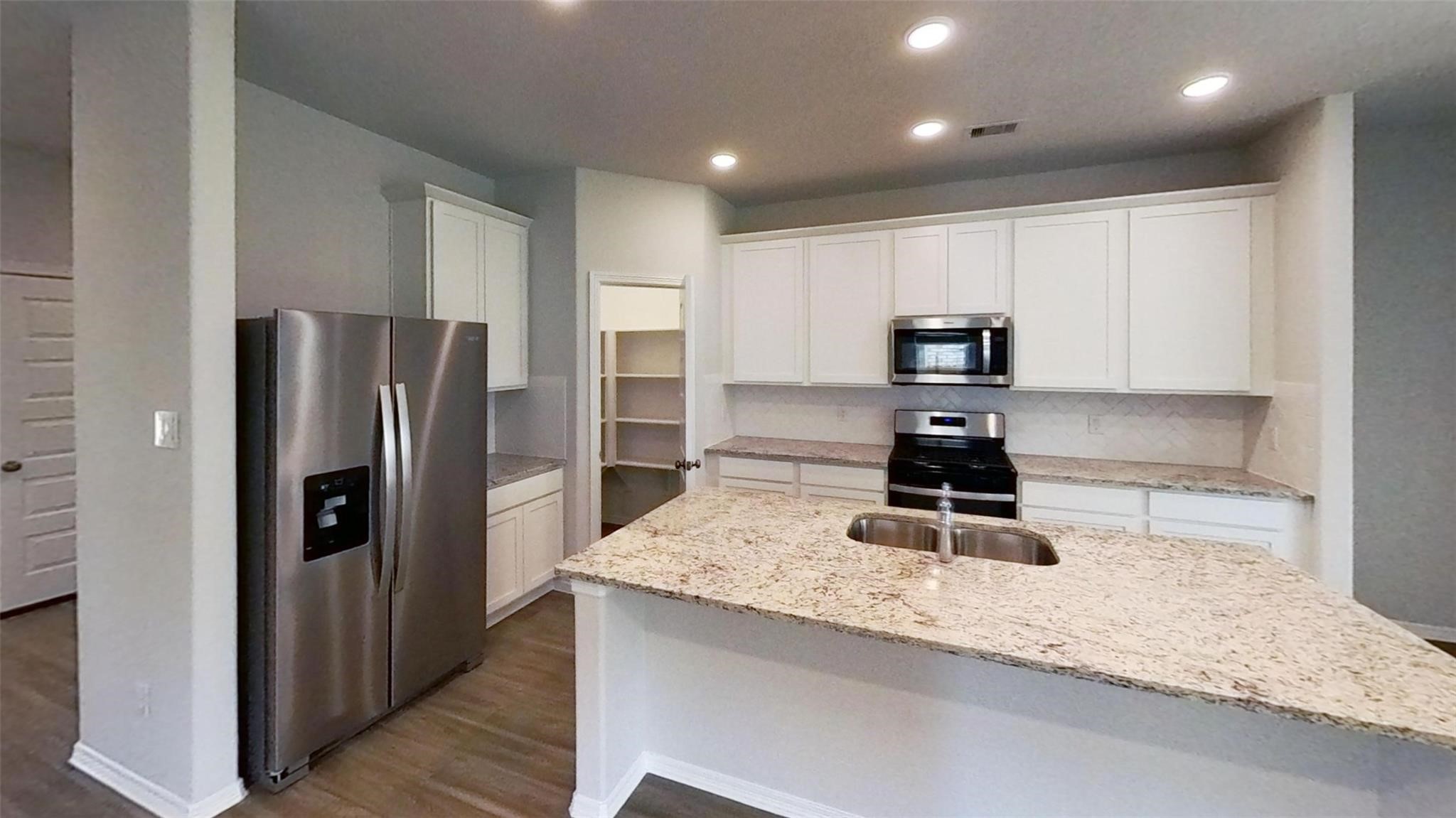 5826 Fresh View Court Katy, TX 77493 - Photo 7 of 7 a kitchen with kitchen island granite countertop stainless steel appliances a refrigerator a stove a sink and a refrigerator