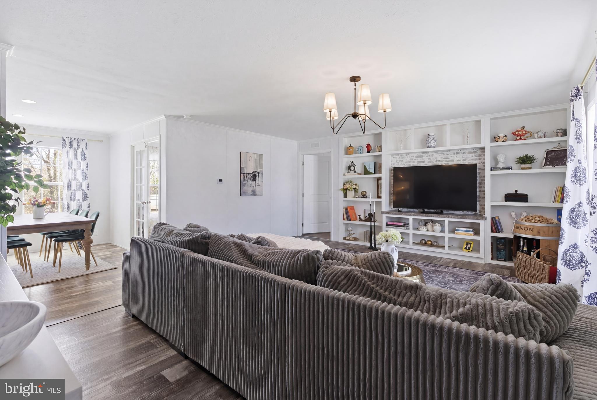 6 Southwind Circle Jackson, NJ 08527 - Photo 2 of 34 a living room with furniture a flat screen tv and a chandelier
