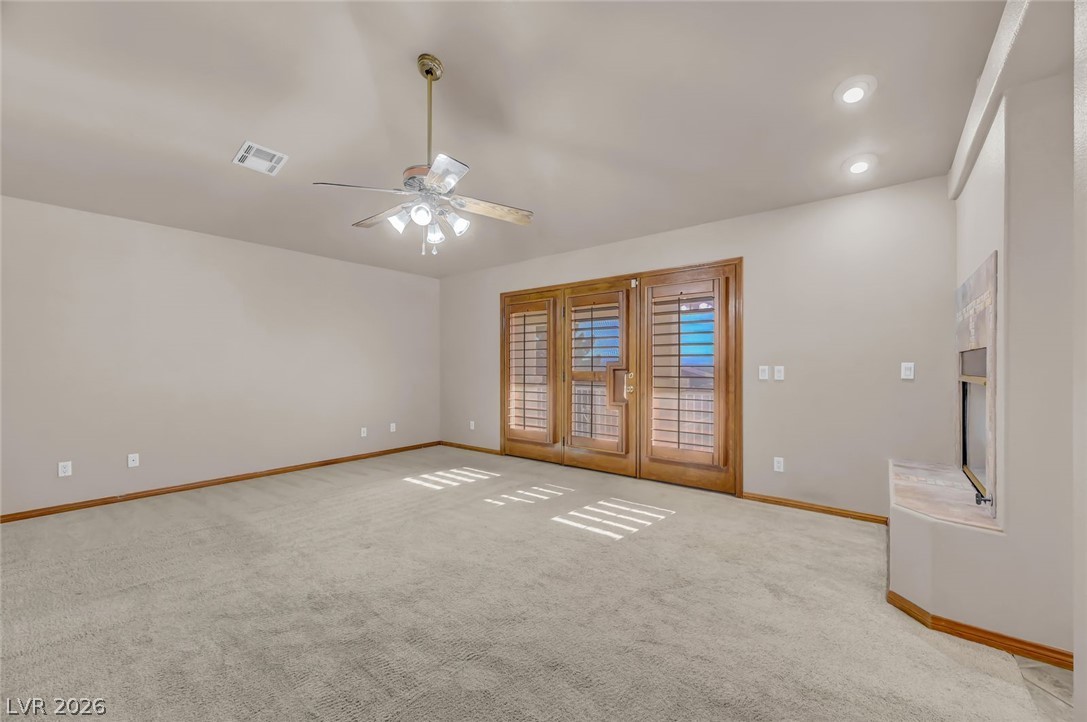 640 North Racetrack Road Henderson, NV 89015 - Photo 44 of 65 A spacious room features plush carpet and double French doors, inviting natural light.
