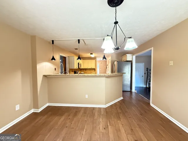 a view of a kitchen with wooden floor and a sink