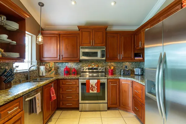 a kitchen with stainless steel appliances granite countertop a stove refrigerator and microwave