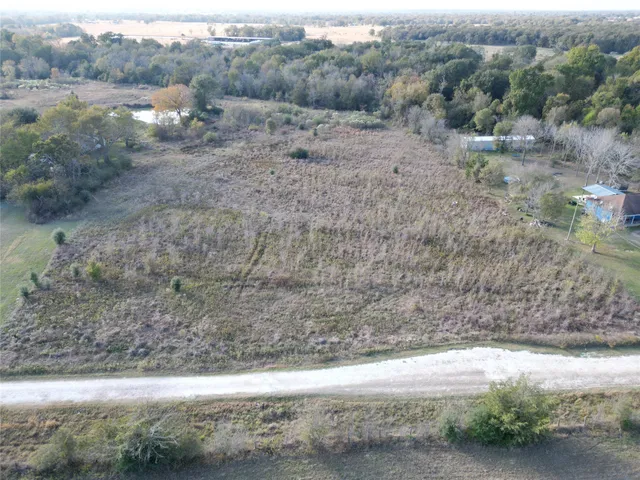 a view of a dry yard with trees