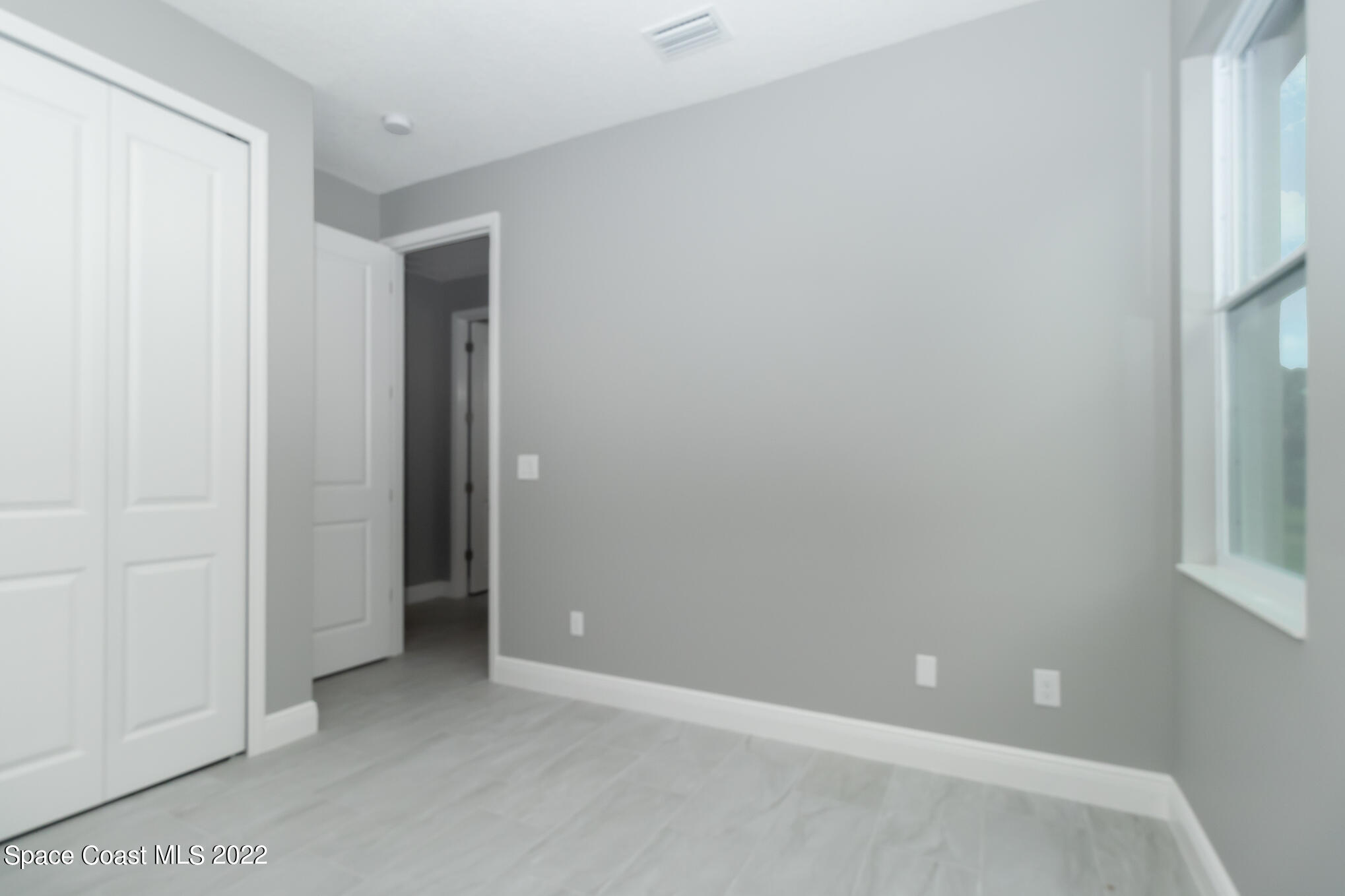 295 San Marino Road Southwest Palm Bay, FL 32908 - Photo 13 of 49 an empty room with windows and closet