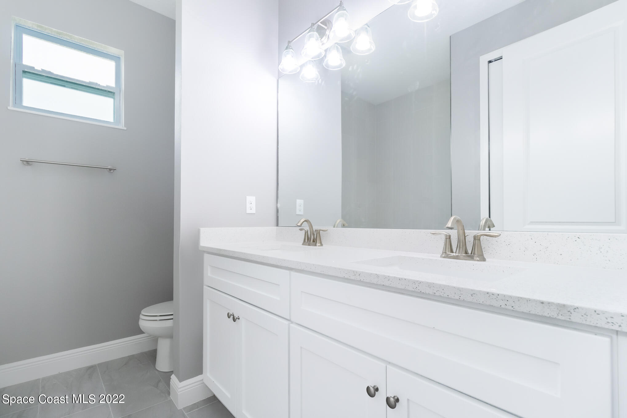 295 San Marino Road Southwest Palm Bay, FL 32908 - Photo 15 of 49 a bathroom with a granite countertop sink a toilet and a mirror