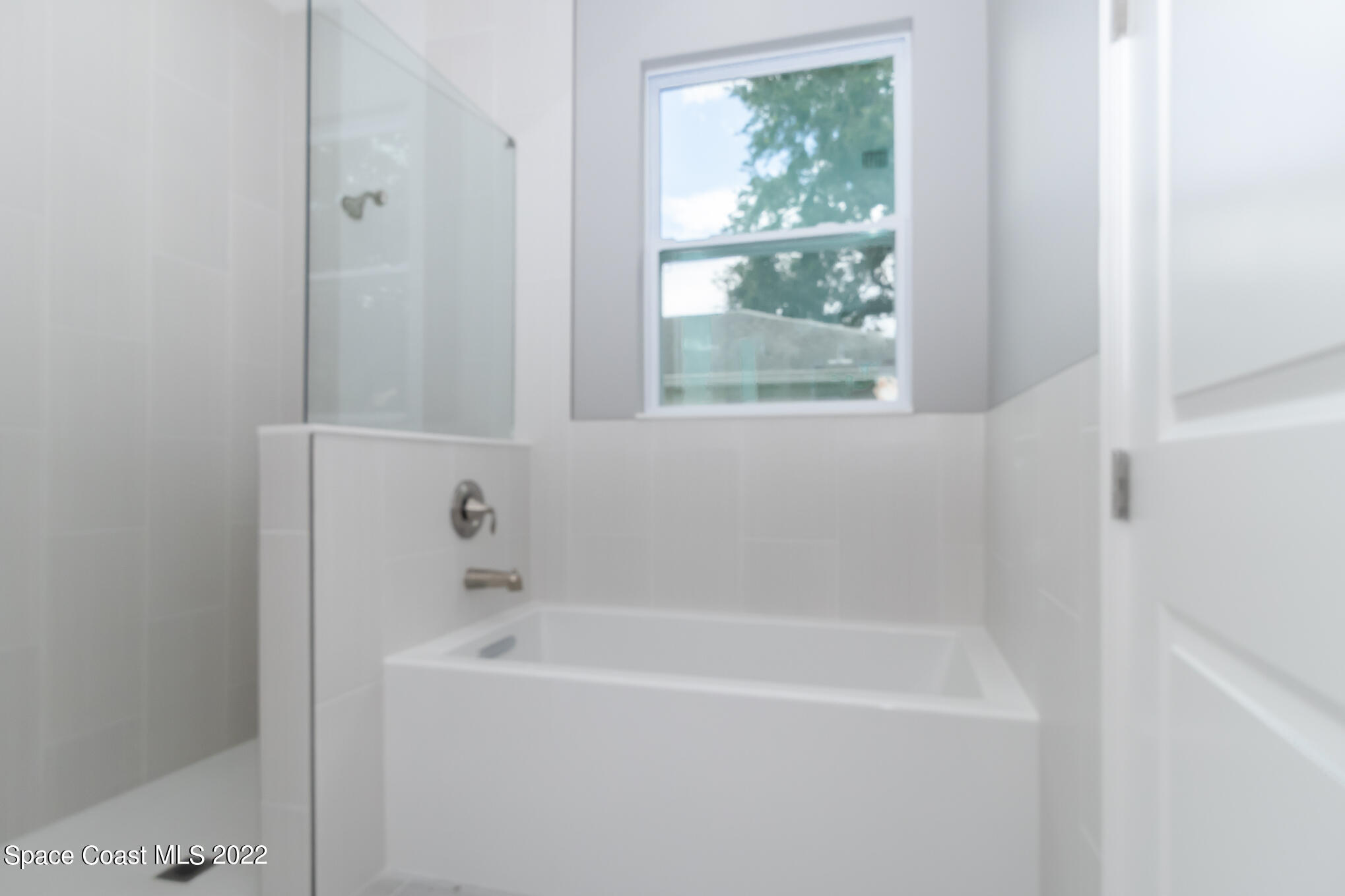295 San Marino Road Southwest Palm Bay, FL 32908 - Photo 17 of 49 a white bath tub sitting next to a window